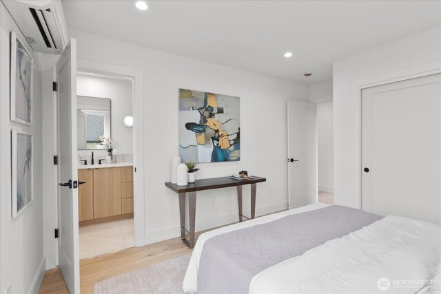 747 N 71st St, Seattle, WA 98103 - bedroom with an AC wall unit, light wood-style flooring, recessed lighting, and connected bathroom