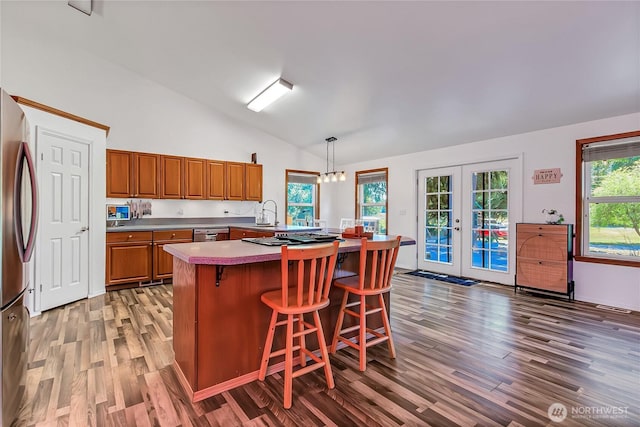 12310 Morris Rd SE, Yelm, WA 98597 - kitchen featuring lofted ceiling, stainless steel appliances, light wood finished floors, brown cabinets, and light countertops