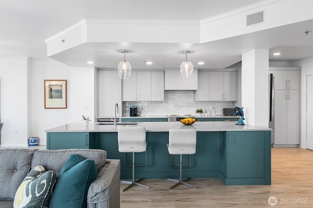 177 107th Ave NE Unit 1906, Bellevue, WA 98004 - kitchen with tasteful backsplash, light wood-type flooring, crown molding, light countertops, and a kitchen bar