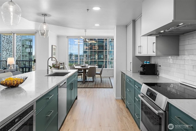 177 107th Ave NE Unit 1906, Bellevue, WA 98004 - kitchen with appliances with stainless steel finishes, wall chimney exhaust hood, green cabinetry, recessed lighting, and light wood-style flooring