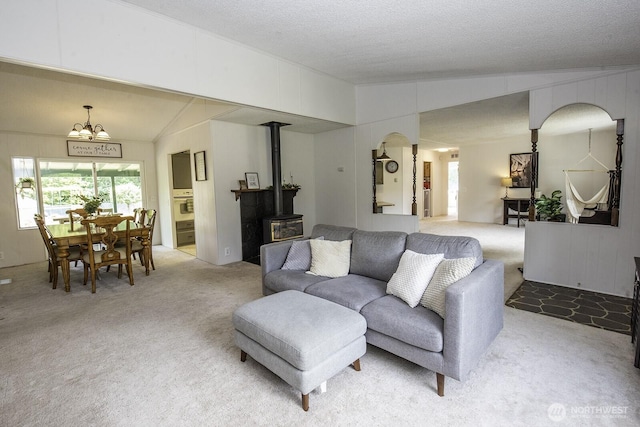 1729 154th St S, Spanaway, WA 98387 - living area with a wood stove, light carpet, a chandelier, arched walkways, and lofted ceiling
