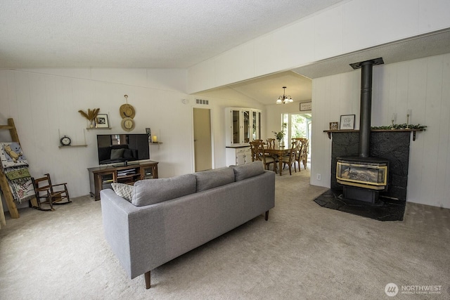 1729 154th St S, Spanaway, WA 98387 - living room with a wood stove, vaulted ceiling, light carpet, a chandelier, and a textured ceiling