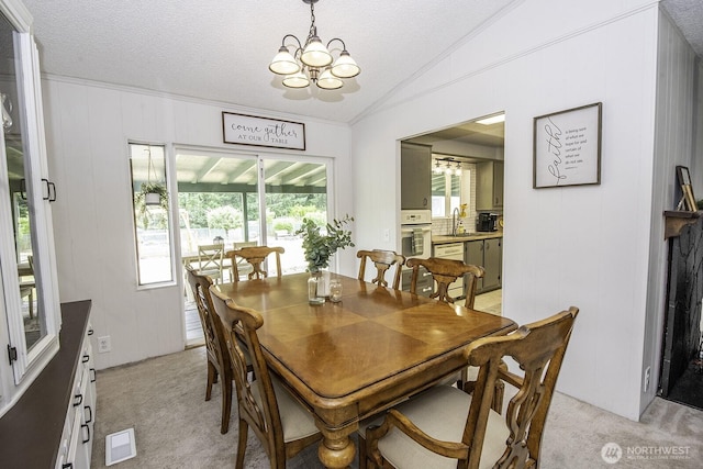 1729 154th St S, Spanaway, WA 98387 - dining area featuring a chandelier, light colored carpet, healthy amount of natural light, vaulted ceiling, and ornamental molding