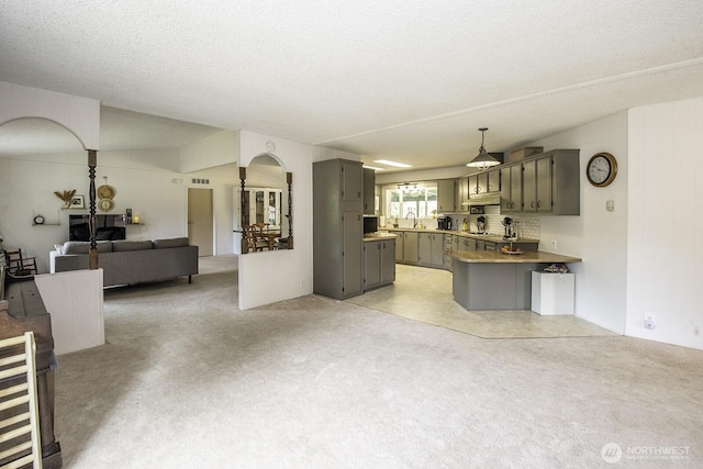 1729 154th St S, Spanaway, WA 98387 - kitchen featuring gray cabinets, open floor plan, a peninsula, arched walkways, and light carpet