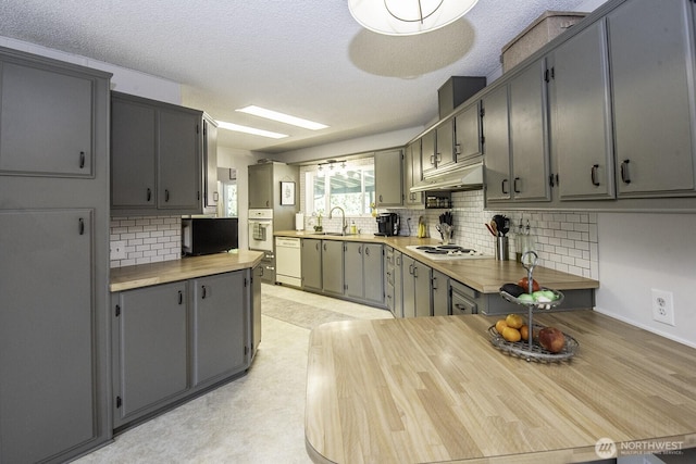 1729 154th St S, Spanaway, WA 98387 - kitchen with white appliances, gray cabinetry, under cabinet range hood, backsplash, and light countertops