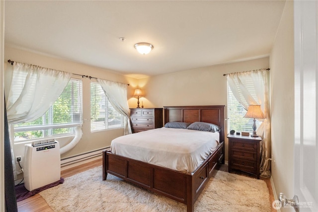 6137 Hazel Loop SE Unit D, Auburn, WA 98092 - bedroom with multiple windows, a baseboard radiator, and wood finished floors