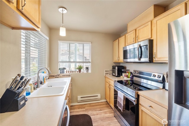 6137 Hazel Loop SE Unit D, Auburn, WA 98092 - kitchen with appliances with stainless steel finishes, light brown cabinetry, baseboard heating, light countertops, and light wood-style flooring