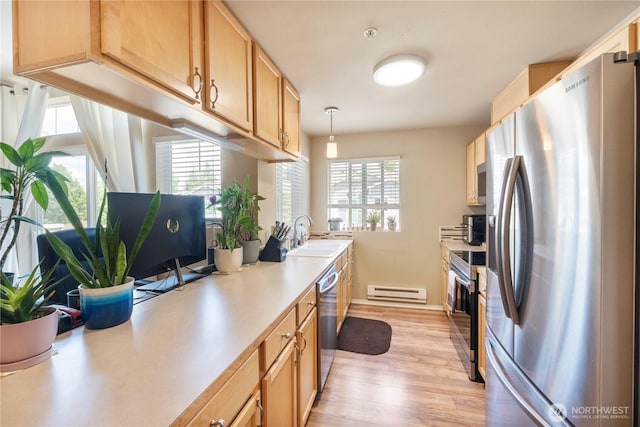 6137 Hazel Loop SE Unit D, Auburn, WA 98092 - kitchen with appliances with stainless steel finishes, a baseboard heating unit, light countertops, light wood-type flooring, and decorative light fixtures