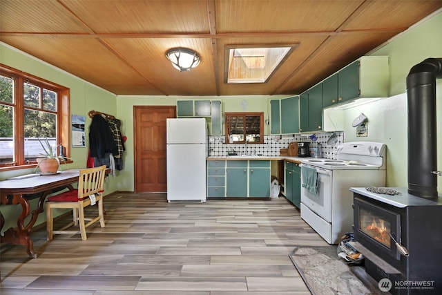 30124 Ramstad Rd, Arlington, WA 98223 - kitchen featuring white appliances, a wood stove, green cabinets, wood ceiling, and a skylight