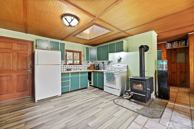 30124 Ramstad Rd, Arlington, WA 98223 - kitchen featuring white appliances, green cabinets, a wood stove, light wood-style floors, and wood ceiling