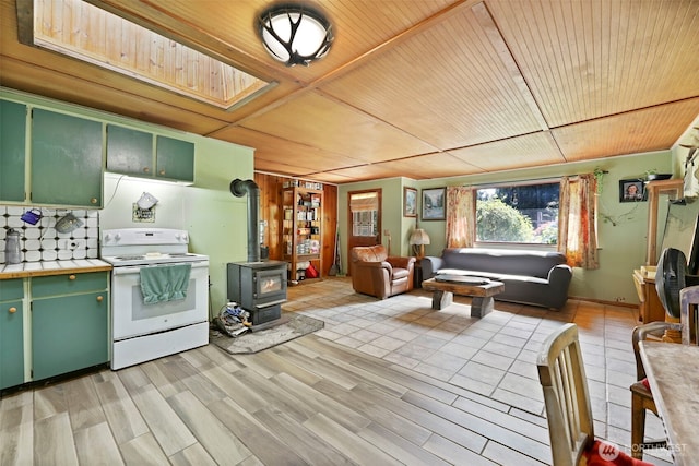 30124 Ramstad Rd, Arlington, WA 98223 - kitchen featuring white electric stove, a wood stove, green cabinetry, tile counters, and wood ceiling