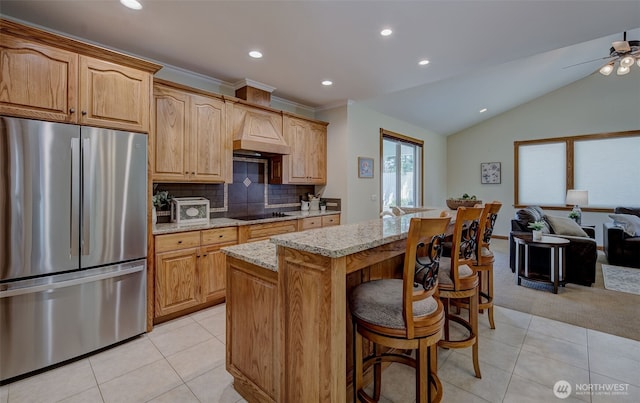 3716 Knowles Rd, Wenatchee, WA 98801 - kitchen featuring freestanding refrigerator, light stone counters, light tile patterned floors, a breakfast bar area, and recessed lighting
