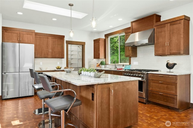 13830 Old Snohomish Monroe Rd, Snohomish, WA 98290 - kitchen featuring appliances with stainless steel finishes, wall chimney exhaust hood, a center island, a kitchen breakfast bar, and decorative backsplash