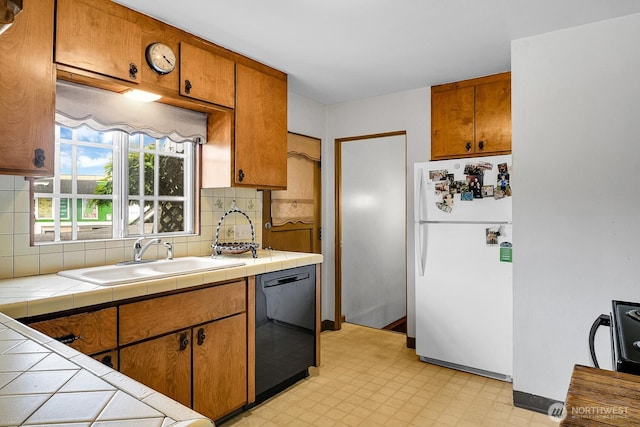 9713 4th Ave W, Everett, WA 98204 - kitchen with freestanding refrigerator, black dishwasher, tile countertops, light floors, and backsplash
