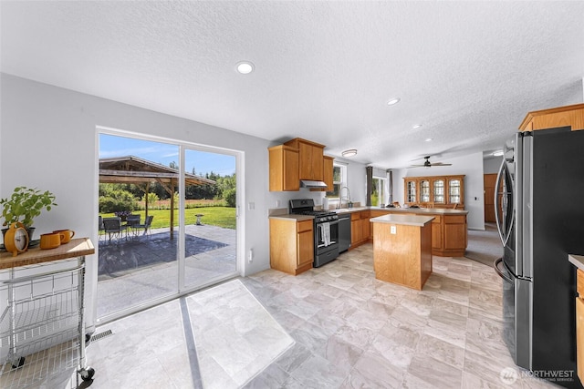 8654 Valley View Rd, Custer, WA 98240 - kitchen featuring gas stove, freestanding refrigerator, a textured ceiling, a peninsula, and ceiling fan