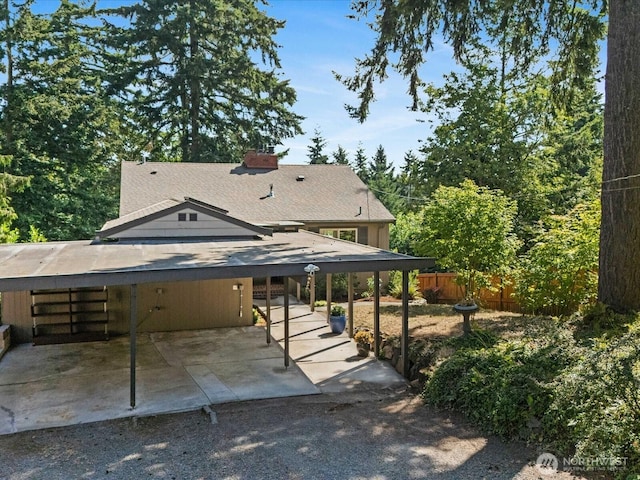13514 3rd Ave NE, Seattle, WA 98125 - rear view of house with a patio area, a chimney, and a carport