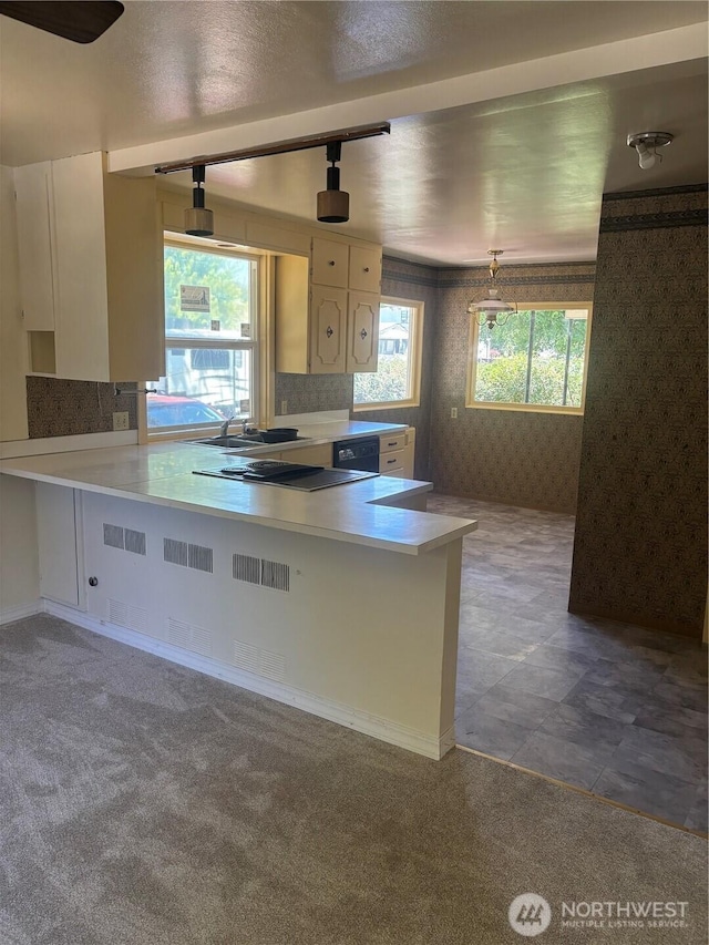 214 N 2nd St, Dayton, WA 99328 - kitchen with wallpapered walls, white cabinets, light countertops, a peninsula, and black appliances