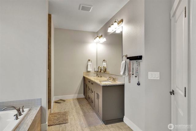 9511 W Floyd Dr, Cheney, WA 99004 - full bath with double vanity, a garden tub, and wood finished floors