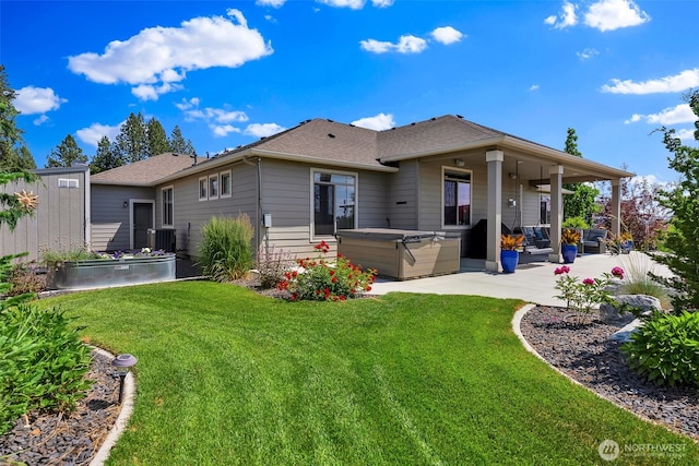 9511 W Floyd Dr, Cheney, WA 99004 - rear view of house featuring a hot tub, a patio area, a yard, and roof with shingles