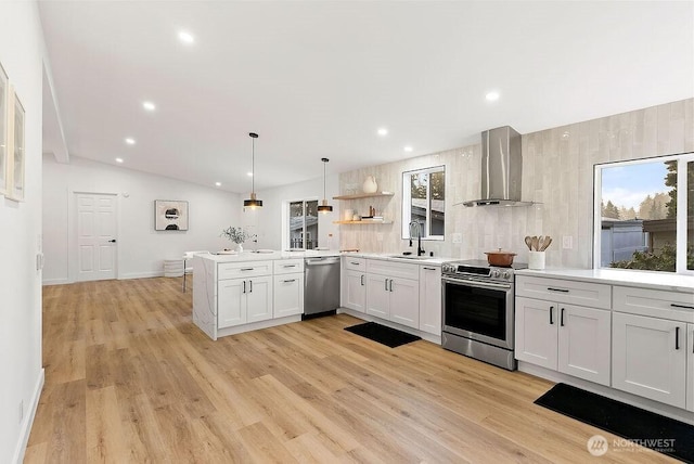 2500 S 370th Unit 227, Federal Way, WA 98003 - kitchen with wall chimney range hood, appliances with stainless steel finishes, a peninsula, light countertops, and light wood-style flooring