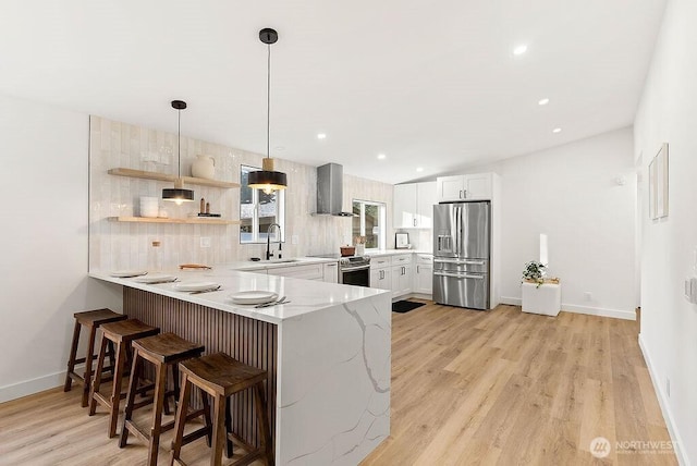 2500 S 370th Unit 227, Federal Way, WA 98003 - kitchen with appliances with stainless steel finishes, wall chimney exhaust hood, a peninsula, light stone counters, and backsplash
