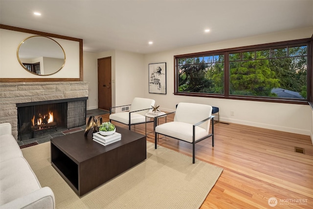 5244 Pullman Ave NE, Seattle, WA 98105 - living area featuring a stone fireplace, wood finished floors, and recessed lighting