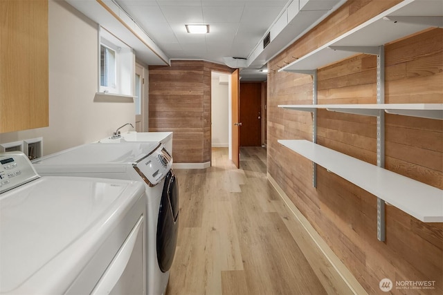 5244 Pullman Ave NE, Seattle, WA 98105 - washroom with separate washer and dryer, wooden walls, and light wood-style floors
