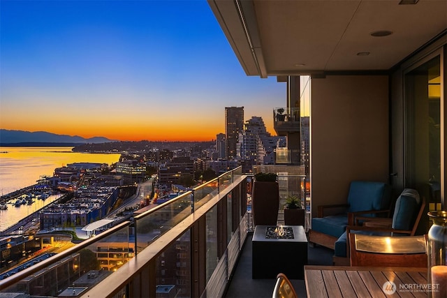 99 Union St Unit 1601, Seattle, WA 98101 - balcony at dusk with a fire pit, a city view, and a water view