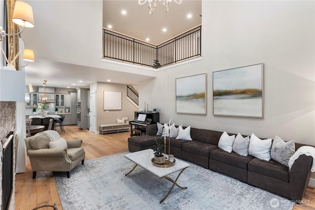 230 155th Pl SE, Bothell, WA 98012 - living room with light wood-style flooring, stairs, a high ceiling, a chandelier, and recessed lighting