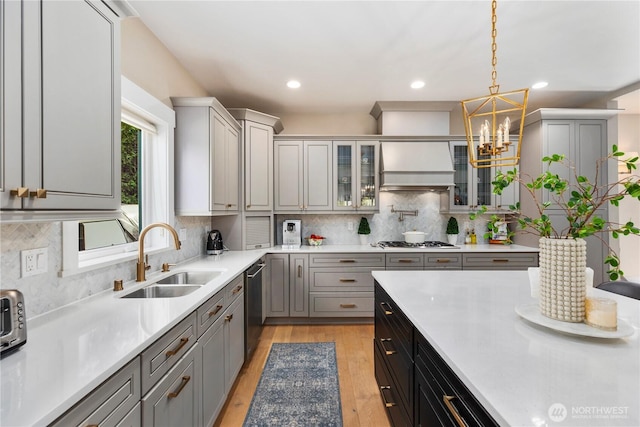 230 155th Pl SE, Bothell, WA 98012 - kitchen with custom exhaust hood, gray cabinets, appliances with stainless steel finishes, a chandelier, and glass insert cabinets