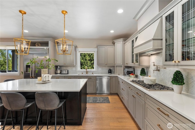 230 155th Pl SE, Bothell, WA 98012 - kitchen with stainless steel appliances, a chandelier, gray cabinets, a kitchen breakfast bar, and custom range hood