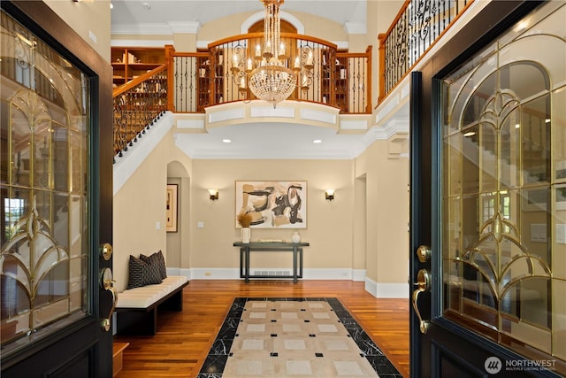 2530 39th Ave E, Seattle, WA 98112 - entryway featuring inlaid floor details, arched walkways, a high ceiling, crown molding, and stairway