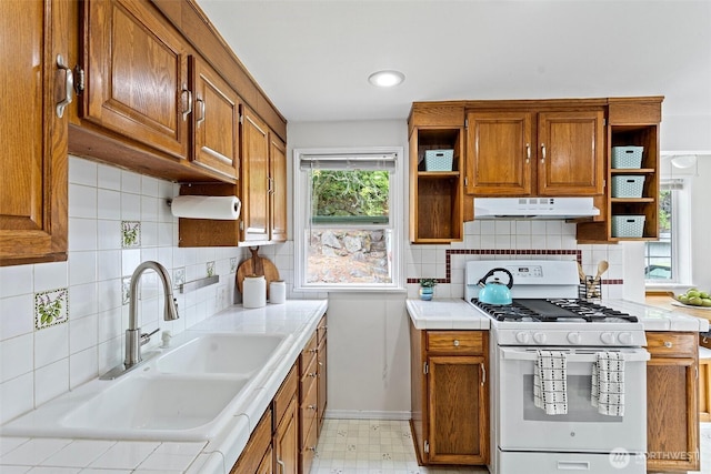 7147 29th Ave SW, Seattle, WA 98126 - kitchen with gas range gas stove, under cabinet range hood, open shelves, and brown cabinetry