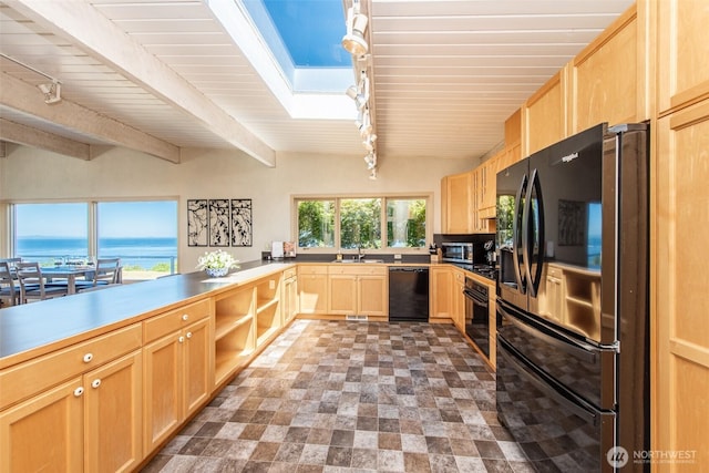2641 E Bay St, Port Angeles, WA 98362 - kitchen with black appliances, light brown cabinetry, a skylight, rail lighting, and a wood ceiling with exposed beams