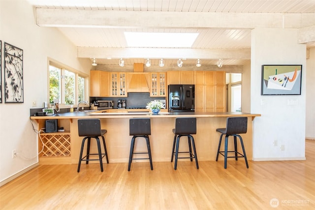2641 E Bay St, Port Angeles, WA 98362 - kitchen featuring black fridge, track lighting, a peninsula, light wood-type flooring, and a wooden ceiling with exposed beams