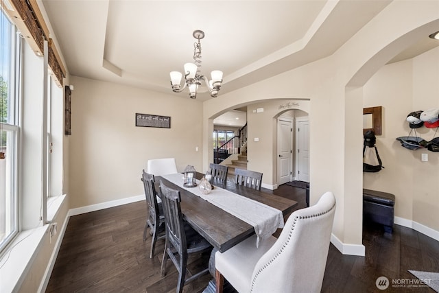 17116 138th Ave E, Puyallup, WA 98374 - dining space with a chandelier, arched walkways, a raised ceiling, wood finished floors, and stairway