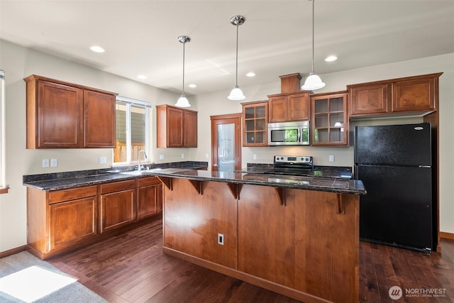 2309 43rd Ave SE, Puyallup, WA 98374 - kitchen featuring appliances with stainless steel finishes, dark wood-style floors, glass insert cabinets, a kitchen bar, and recessed lighting