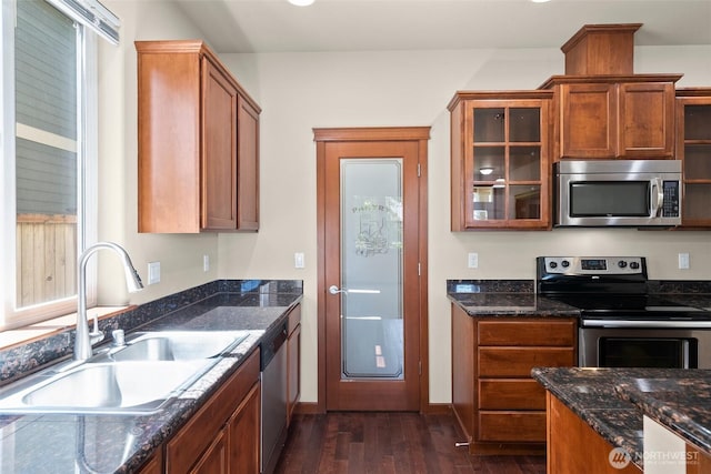 2309 43rd Ave SE, Puyallup, WA 98374 - kitchen with appliances with stainless steel finishes, dark wood-style flooring, glass insert cabinets, dark stone countertops, and brown cabinetry