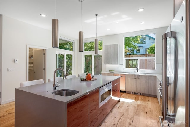 6012 Palatine Ave N, Seattle, WA 98103 - kitchen with modern cabinets, stainless steel appliances, light wood-style floors, recessed lighting, and an island with sink
