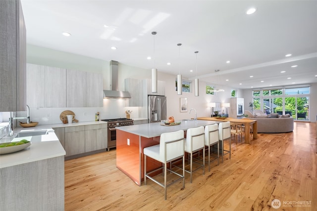 6012 Palatine Ave N, Seattle, WA 98103 - kitchen featuring high end appliances, modern cabinets, wall chimney range hood, light wood-style floors, and light countertops