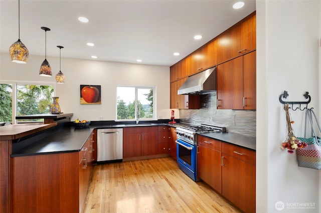 788 P St, Port Townsend, WA 98368 - kitchen with stainless steel appliances, ventilation hood, dark countertops, light wood-style flooring, and recessed lighting