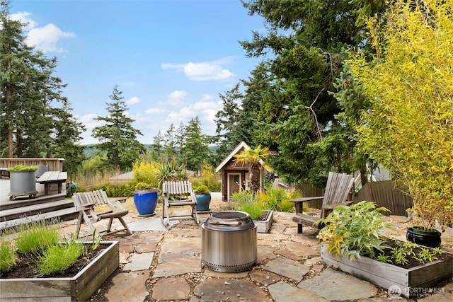 788 P St, Port Townsend, WA 98368 - view of patio / terrace with a vegetable garden, an outdoor structure, and an outdoor fire pit