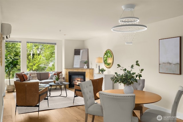 220 1st St Unit 204, Kirkland, WA 98033 - dining area featuring light wood-style flooring, a tile fireplace, and a wall mounted air conditioner