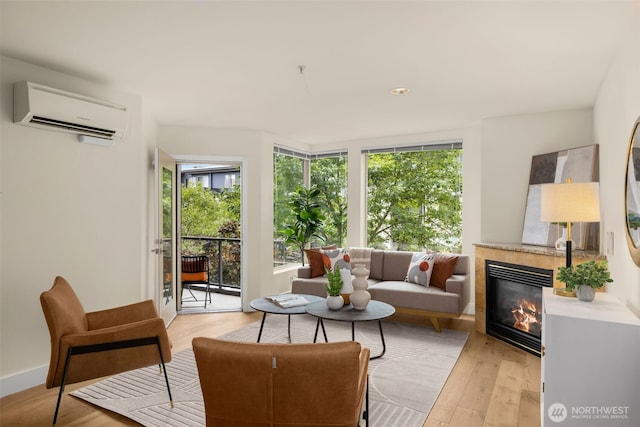 220 1st St Unit 204, Kirkland, WA 98033 - living area with a wall mounted AC, healthy amount of natural light, a fireplace, and light wood-style floors