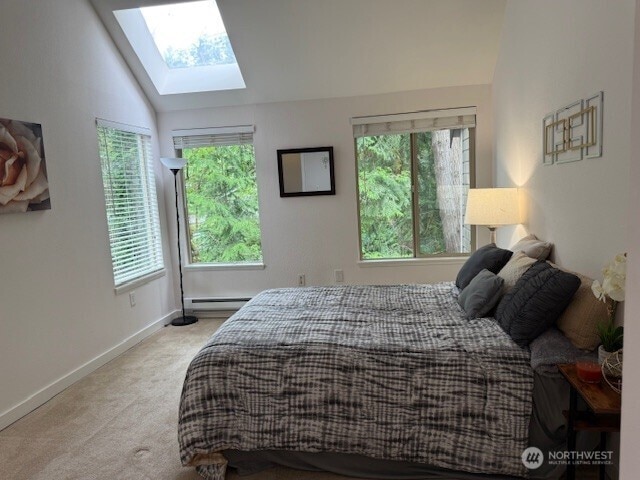 1555 Union Ave NE Unit 56, Renton, WA 98059 - carpeted bedroom with a skylight, multiple windows, vaulted ceiling, and a baseboard heating unit