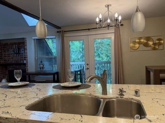 1555 Union Ave NE Unit 56, Renton, WA 98059 - kitchen featuring light stone countertops, pendant lighting, a chandelier, and french doors