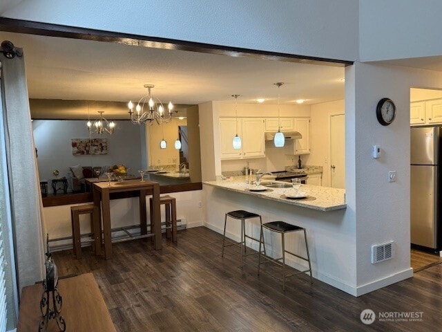 1555 Union Ave NE Unit 56, Renton, WA 98059 - kitchen featuring freestanding refrigerator, white cabinetry, dark wood finished floors, and under cabinet range hood