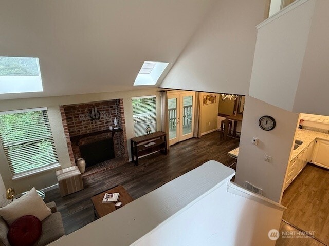 1555 Union Ave NE Unit 56, Renton, WA 98059 - living room featuring a skylight, a brick fireplace, wood finished floors, plenty of natural light, and lofted ceiling