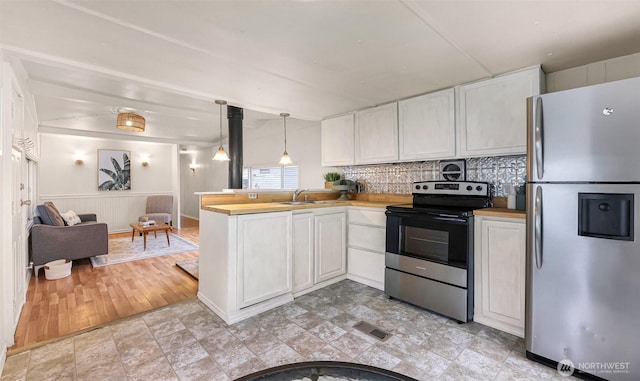 316 W Lake Samish Dr Unit 21, Bellingham, WA 98229 - kitchen with stainless steel appliances, a peninsula, backsplash, open floor plan, and white cabinets