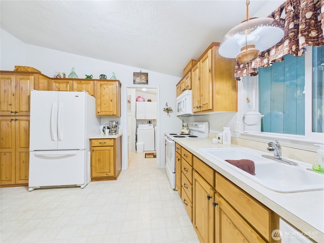 6704 243rd Ave E Unit 96, Buckley, WA 98321 - kitchen with white appliances, washer / dryer, vaulted ceiling, light floors, and light countertops